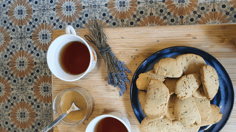 Holiday Herb Cookies: Lavender and Rosemary Shortbread on a wooden board with lavender, honey, and tea.