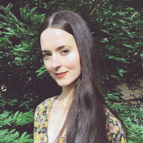 A photo of Lindsay Hills in the forest with a button up, who is an alumni of the Berkeley Herbal Cetner